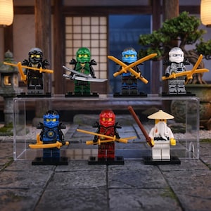 May include: A display of seven Lego Ninjago minifigures. The figures are in various colours, including black, green, blue, red, and white, each with unique ninja attire and weapons. They are presented on a clear acrylic stand.
