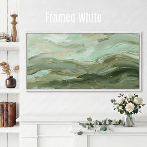 May include: A framed white abstract painting with a textured, layered appearance. The artwork features shades of green and beige, creating a sense of depth and movement. The text "Framed White" is displayed at the top.