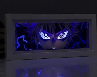Könnte beinhalten: Ein weiß gerahmtes Kunstwerk im Anime-Stil mit blau leuchtendem Innenraum. Das Kunstwerk zeigt das Gesicht einer Figur mit großen, ausdrucksstarken Augen und stacheligen Haaren, die von blauem Licht beleuchtet werden. Der Hintergrund hat blaue Blitzformen.