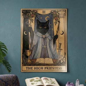 May include: A rectangular wall art print featuring a black cat dressed as The High Priestess tarot card. The illustration includes a blue curtain, pillars, a golden chalice, a sword, and an open book. The text THE HIGH PRIESTESS is at the bottom.