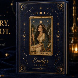 May include: A dark blue hardcover journal featuring gold foil celestial motifs and a central illustration of The Empress tarot card. The cover displays the text 'Emily's JOURNAL' and 'YOUR STORY. YOUR TAROT. Personalized Hardcover Journal'.