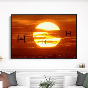 May include: Framed art print featuring a vibrant sunset with a large, bright sun. Silhouetted TIE fighters are visible, adding a sci-fi element. The artwork is displayed above white couches, creating a modern living room aesthetic.