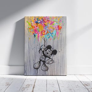 Peut inclure: Une &oelig;uvre d'art sur toile repr&eacute;sentant Mickey Mouse en noir et blanc, tenant des ballons color&eacute;s et abstraits. Le fond est gris textur&eacute;, avec des coulures et des &eacute;claboussures vibrantes de rose, jaune, bleu et orange.