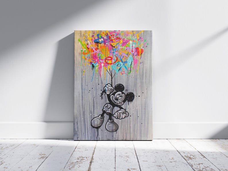 Peut inclure: Une &oelig;uvre d'art sur toile repr&eacute;sentant Mickey Mouse en noir et blanc, tenant des ballons color&eacute;s et abstraits. Le fond est gris textur&eacute;, avec des coulures et des &eacute;claboussures vibrantes de rose, jaune, bleu et orange.