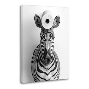May include: Black and white photograph of a zebra with a roll of toilet paper balanced on its head. The zebra is centered, with its distinctive stripes and facial features clearly visible against a white background. The image is a humorous take on wildlife.