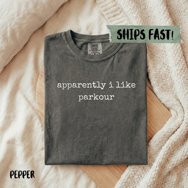 Dark grey t-shirt with "apparently i like parkour" in white text.