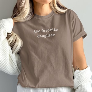 Brown t-shirt with "the favorite daughter" text.