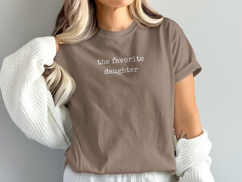 Brown t-shirt with "the favorite daughter" text.
