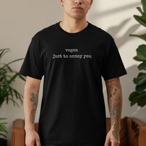 Black t-shirt with "vegan just to annoy you" text.