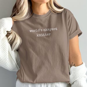 Brown t-shirt with "world's okayest knitter" text on the chest.
