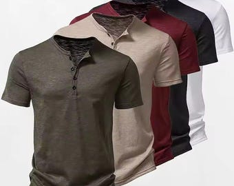 May include: A collection of five short-sleeved henley shirts arranged in a row, featuring a buttoned placket at the neckline. The shirts are presented in a gradient of colors including olive green, beige, maroon, black, and white, all with a textured fabric finish.