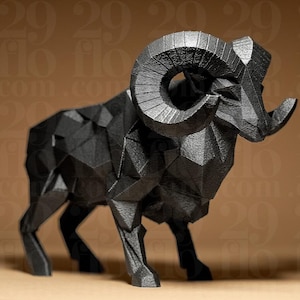 Puede incluir: Escultura geométrica negra de un carnero con cuernos grandes y curvos. El carnero está representado en un estilo de baja poli, con muchas superficies planas y anguladas que crean su forma. La escultura está sobre un fondo marrón.