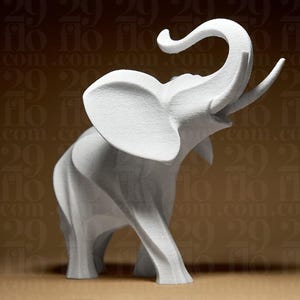 May include: A white elephant sculpture with its trunk raised and large ears. The sculpture has a textured surface and is set against a brown background with repeating text. The elephant is a decorative item.