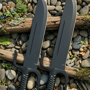 May include: Two identical matte black machetes with curved blades and a prominent fuller. Each knife features a D-guard handle with a textured grip, two visible rivets, and a small upward-curving protrusion near the base of the blade.