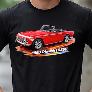 May include: A black t-shirt featuring a graphic of a red 1968 Triumph TR250 convertible sports car. The car is depicted with a motion blur effect underneath it, and the text 1968 Triumph TR250 is printed in white letters below the vehicle.