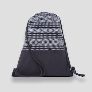 Peut inclure: Un sac à cordon noir avec un motif géométrique blanc et noir sur la partie supérieure. La partie inférieure est noire unie, et le cordon de serrage est une corde noire. Ce sac est adapté pour transporter des vêtements de sport ou d'autres articles.