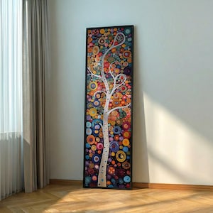 May include: A framed abstract artwork depicting a white tree with colourful circular patterns. The piece has a black frame and is set against a white wall. The circles are in shades of blue, orange, yellow, and purple.