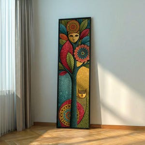 May include: A tall, rectangular framed wall art piece featuring a stylised tree with two cat faces integrated into the design. The artwork uses a vibrant palette of teal, gold, red, and green, with intricate circular mandala patterns and swirling filigree.