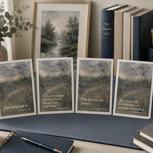 May include: Four art prints with landscape paintings and inspirational quotes. The prints feature a tree in a field with a cloudy sky. The quotes are in white text. A framed landscape painting and books are in the background.