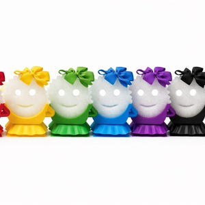 May include: A row of seven smiling, white, spherical figures with glowing eyes. Each figure wears a different colored outfit: red, yellow, green, blue, purple, black, and white. Each has a matching bow on top.