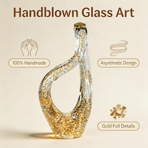 May include: Handblown glass art piece with an asymmetrical design. The clear glass is infused with gold foil details, creating a shimmering effect. The piece is 100% handmade, showcasing a unique, artistic form.