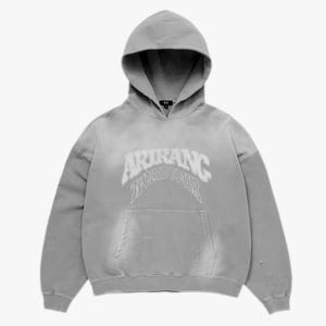 Op de afbeelding: Een vervaagde grijze hoodie met een kangoeroezak aan de voorzijde en lange mouwen. Op de borst staat in witte, gebogen letters de tekst ARIRANG 23 WORLD TOUR. Het kledingstuk heeft een verwassen afwerking met kleine gerafelde details.