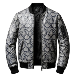 Puede incluir: Chaqueta bomber plateada y azul marino con estampado de piel de serpiente, con cuello, puños y dobladillo negros. La chaqueta tiene cierre de cremallera, dos bolsillos delanteros y un bolsillo pequeño en la manga izquierda.
