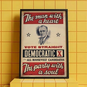 Könnte beinhalten: Ein gerahmtes politisches Plakat mit einem Porträt von Franklin D. Roosevelt. Der Text lautet: The man with a heart, VOTE STRAIGHT DEMOCRATIC X for ALL ROOSEVELT CANDIDATES und The party with a soul. Das Plakat verwendet die Farben Rot, Weiß und Blau.
