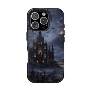 May include: A phone case featuring a gothic castle scene under a dark, stormy sky. The artwork includes a volcano, bats, and a graveyard, creating a spooky, atmospheric design. The case has a black border and a camera cutout.