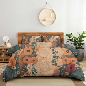 Puede incluir: Un juego de cama que incluye una funda nórdica y dos fundas de almohada a juego con un patrón repetitivo de flores naranjas y motivos circulares en color verde azulado sobre un fondo crema y verde azulado oscuro con formas fluidas.