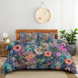 May include: A duvet cover and two matching pillowcases featuring an abstract pattern of orange, pink, and teal circular floral shapes on a dark blue background. The bedding set displays a vibrant, painterly design with layered dots and circles.