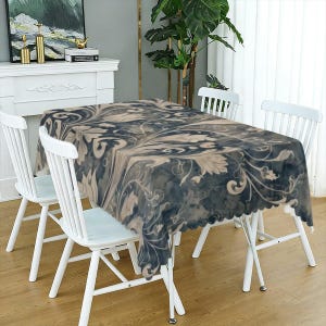May include: A rectangular tablecloth featuring a dark navy blue and cream-colored floral pattern with swirling, ornate botanical motifs. The fabric has a scalloped edge and drapes over a table, displaying a continuous, intricate design.