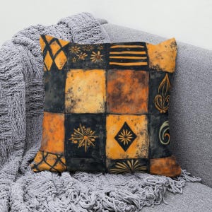 May include: A square throw pillow featuring a patchwork grid design in shades of black and orange. The pattern consists of alternating squares with various motifs including floral elements, horizontal stripes, diamonds, and stylized scrollwork.