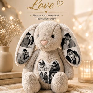 Op de afbeelding: Een beige pluche knuffelkonijn met lange oren en een zachte textuur. Het konijn is voorzien van aangepaste zwart-wit fotoprints op de oren en een hartvormige patch op de borst. De tekst erboven luidt Made of Love en Keeps your sweetest memories close.