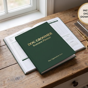 May include: A dark green "Dog Groomer Business Planner" with gold lettering, open on a wooden surface. The planner is next to a pair of gold scissors, a comb, and a small potted plant. The text "Instant Digital Download" is in a gold circle.
