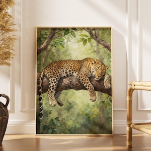 May include: A framed art print depicting a leopard resting on a tree branch. The leopard has a tan coat with black spots. The background is a verdant green forest with sunlight filtering through the leaves.
