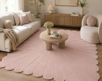 Alfombra rosa palo con pétalos de margarita festoneados, de lana tejida a mano con diseño de rayos de sol.