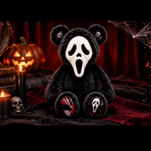 May include: A black plush teddy bear featuring a white Ghostface mask hood. The bear has small Ghostface icons on its ears. One foot pad displays a red and white blood splatter design, while the other foot pad features a white Ghostface mask graphic.