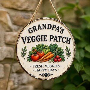 May include: A round, cream-colored hanging sign with a distressed edge, featuring the black text GRANDPA'S VEGGIE PATCH, an illustration of tomatoes, carrots, and leafy greens, and the text FRESH VEGGIES HAPPY DAYS with a small black scroll accent.