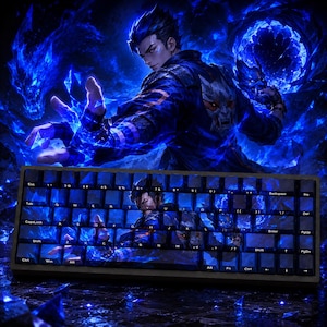 Op de afbeelding: Een mechanisch toetsenbord met een aangepaste set toetsen met een levendige blauwe grafische print van een mannelijk personage in een donker jasje, omringd door gloeiende blauwe energie-effecten en kristalachtige scherven op een donkerblauwe achtergrond.