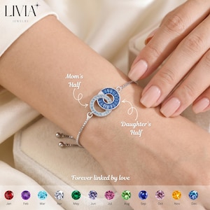 May include: Silver bracelet with two interlocking circles, one blue and one with clear stones. Text reads "Mom's Half" and "Daughter's Half". The bracelet is labeled "Forever linked by love".