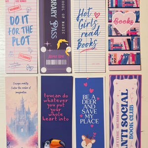 May include: A set of eight rectangular paper bookmarks featuring various designs, including a crime scene note, a magic school pass, a library card, a bookshelf, a fantasy castle, a toucan, a deer, and an anti-social book club membership card.