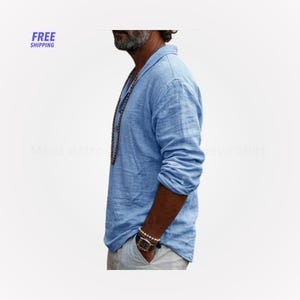 Peut inclure: Chemise &agrave; manches longues bleu clair avec un col. La chemise est faite d'un tissu l&eacute;ger et a une coupe d&eacute;contract&eacute;e. L'image comprend &eacute;galement le texte "FREE SHIPPING".