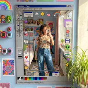 May include: A rectangular wall mirror designed to resemble the user interface of the classic Microsoft Paint software. The frame features a grey toolbar, a colour palette, and various colourful digital stickers like rainbows, hearts, and a cat.