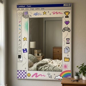Könnte beinhalten: Ein rechteckiger Wandspiegel mit einem weißen Rahmen, der mit einer Benutzeroberfläche eines Retro-Malprogramms bedruckt ist. Der Rand zeigt pixelige Symbole wie einen Computer, einen Pokal, ein Herz, einen Controller und einen Regenbogen.