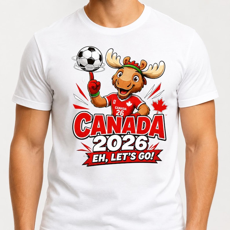 May include: A white t-shirt featuring a cartoon moose wearing a red jersey with the number 26 and a maple leaf. The moose spins a soccer ball on its finger. Below, the text reads CANADA 2026 and EH, LET'S GO! on a red banner graphic.