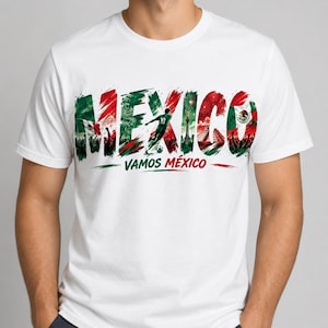 Może przedstawiać: Biała koszulka z napisem "MEXICO" w kolorze czerwonym, zielonym i białym, z grafiką piłkarza i napisem "VAMOS M&Eacute;XICO". Projekt zawiera elementy meksykańskiej flagi i obrazy kulturowe.