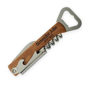 May include: A wooden handled bottle opener with a corkscrew and a bottle opener. The handle is engraved with the text "Alexander John - Best Man".