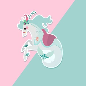 Pode incluir: Um cavalo-marinho branco e azul com uma sela rosa e detalhes florais. O cavalo-marinho est&aacute; sobre um fundo rosa e azul.