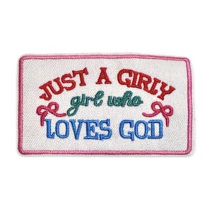 Puede incluir: Un parche rectangular bordado con fondo blanco y borde rosa. El texto dice JUST A GIRLY en rojo, girl who en verde y LOVES GOD en azul. Dos pequeños lazos rosas están bordados a los lados izquierdo y derecho del texto.